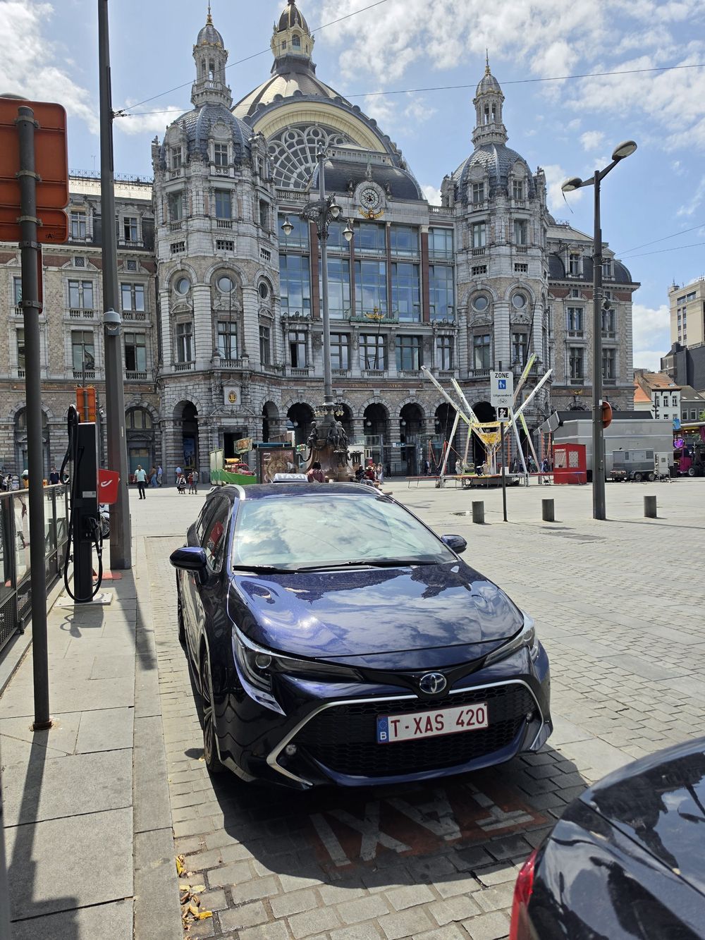 Donkerblauwe Toyota Corolla Touring Sports taxi aan Antwerpen-Centraal