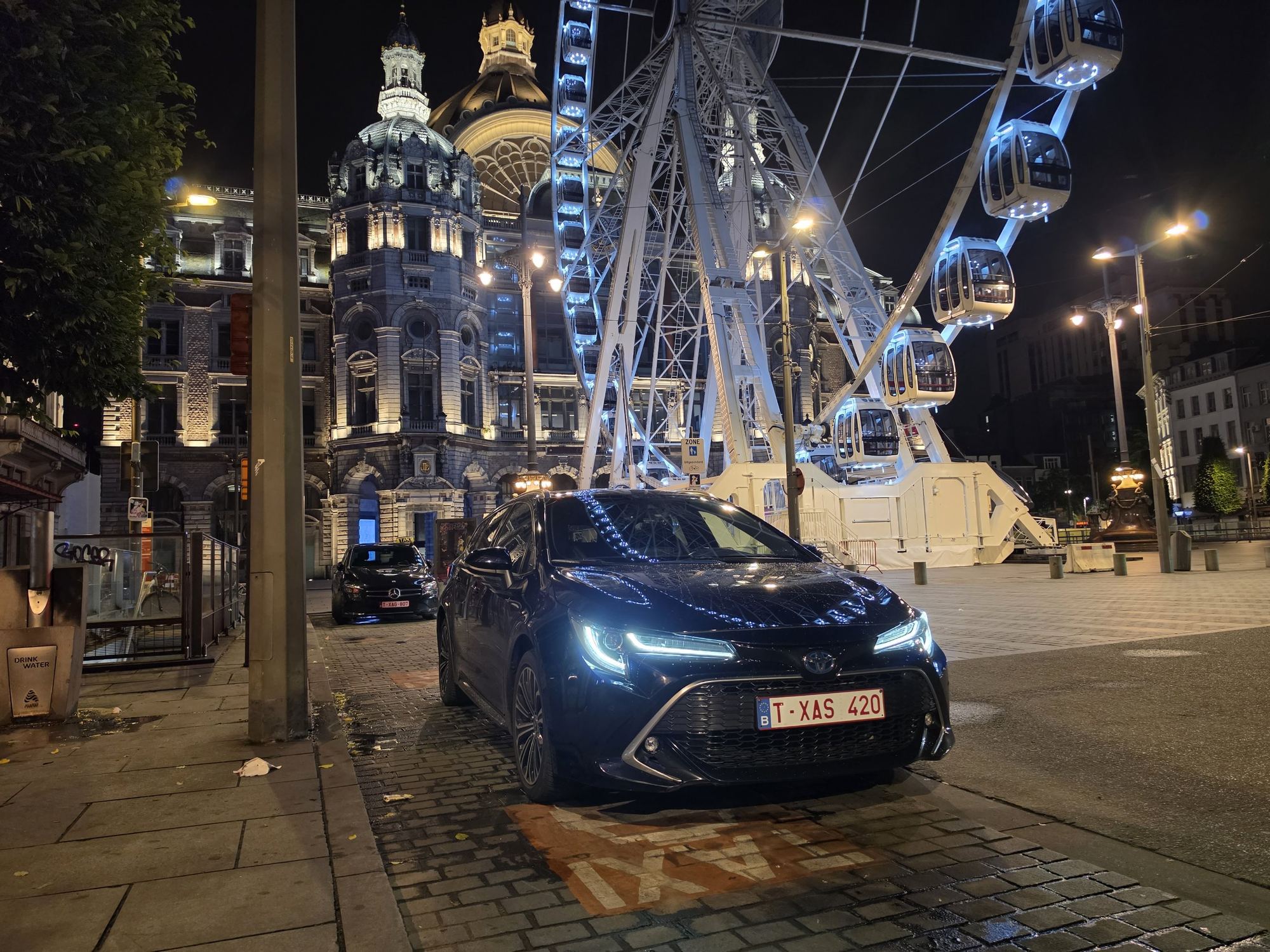 Ramys taxi bij het reuzenrad en station Antwerpen-Centraal bij nacht